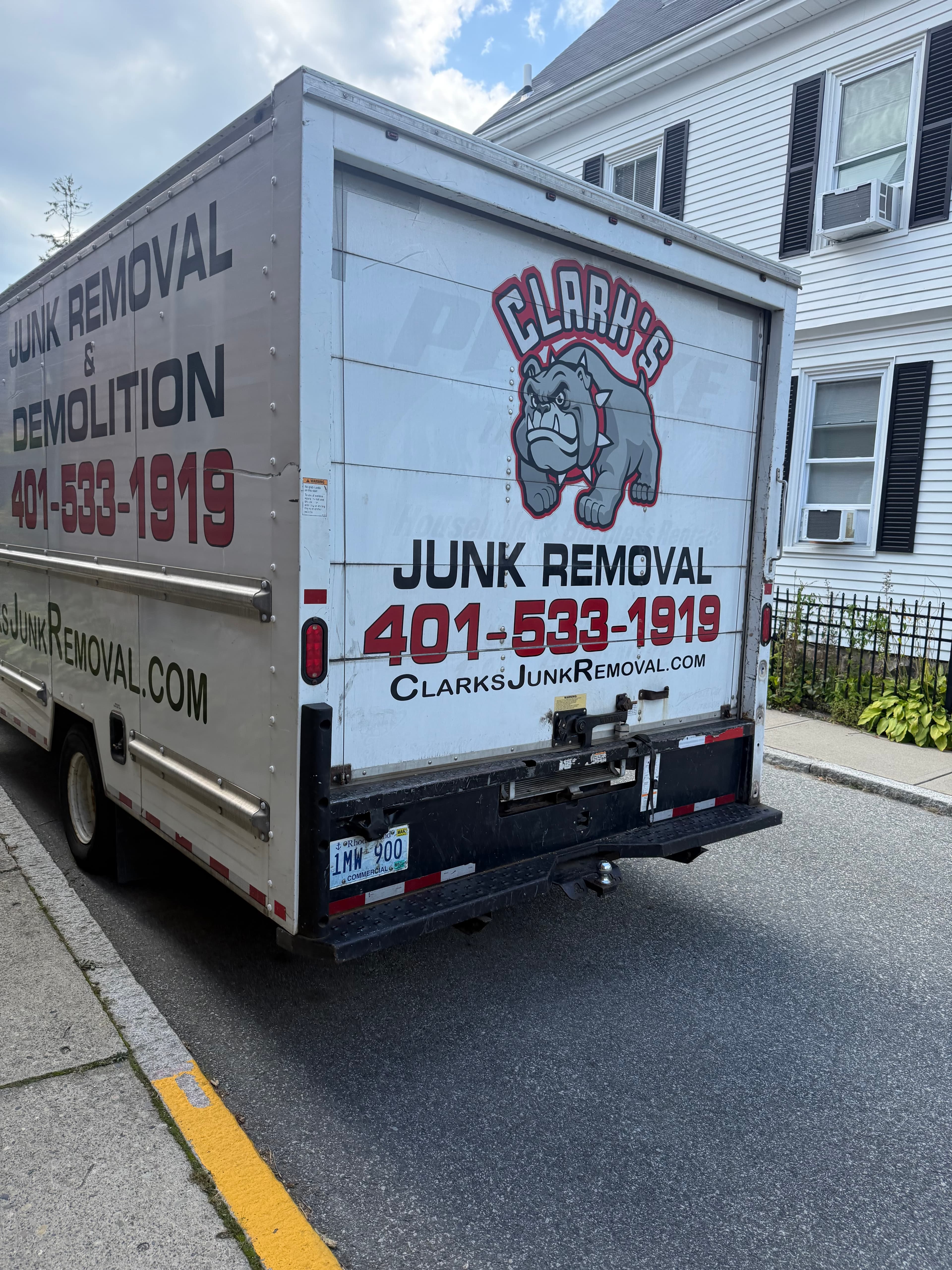 Clark's Junk Removal branded red and white work truck parked on a Rhode Island residential street